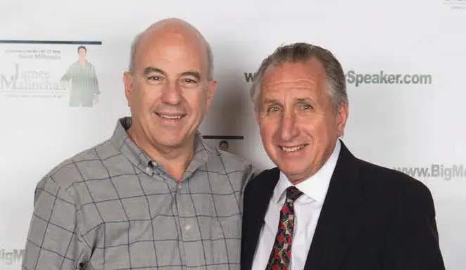 Two men smiling at a formal event.