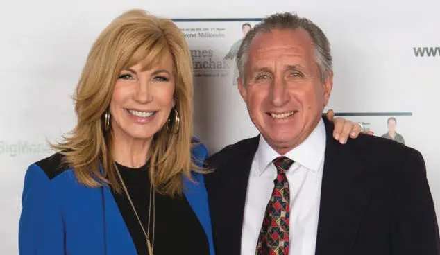 Smiling man and woman at event.