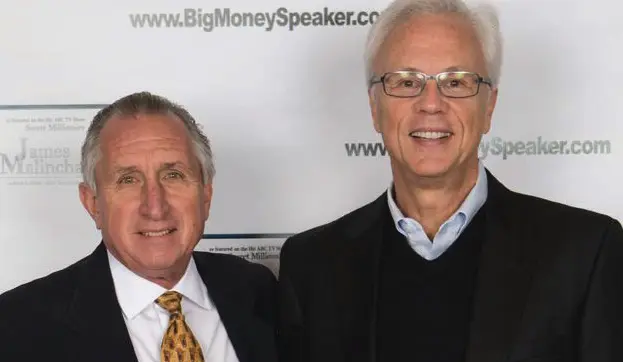Two men standing in front of backdrop.