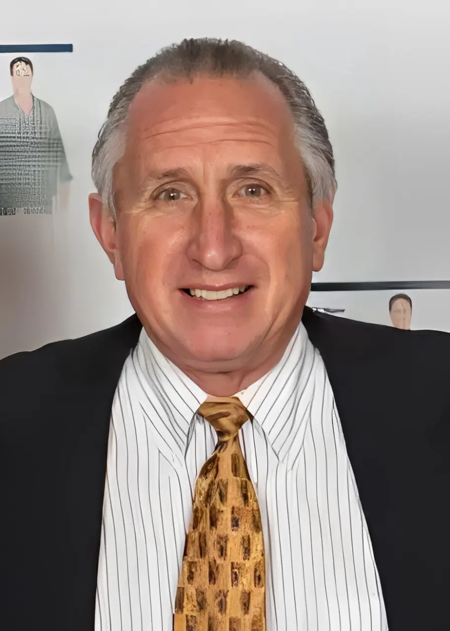 Man smiling in suit and tie.