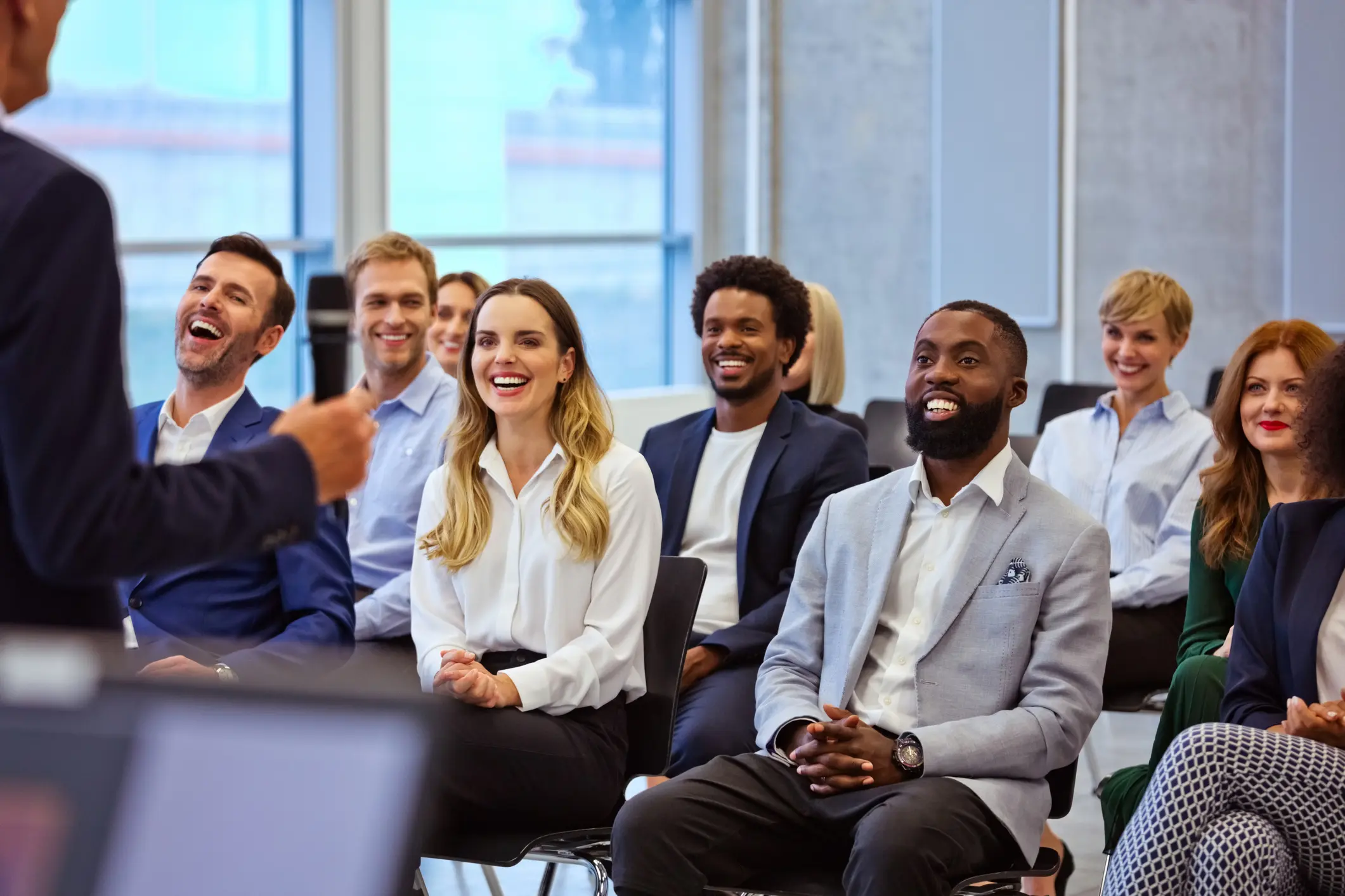 Audience laughing during a business presentation.