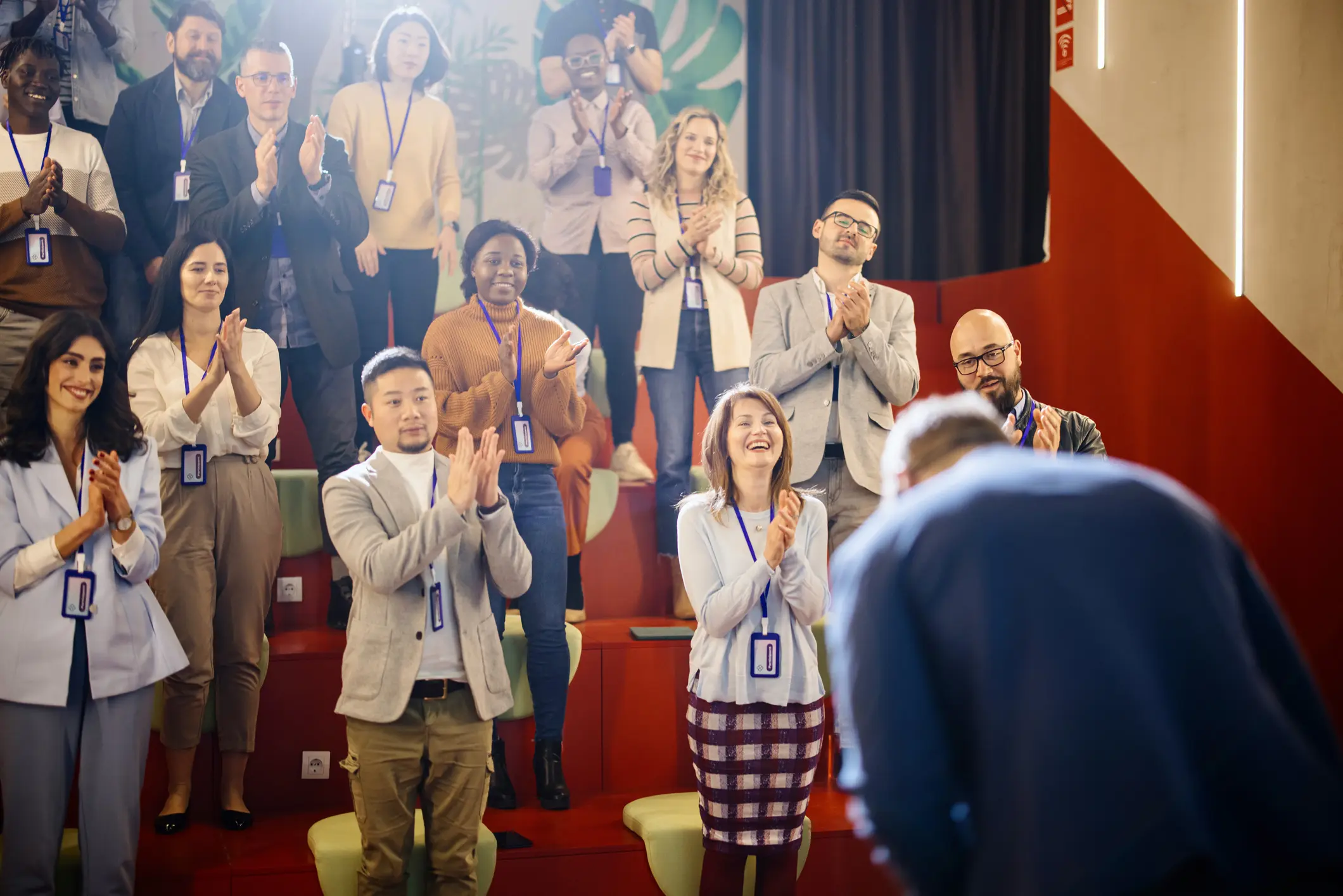 Audience clapping for a speaker on stage.