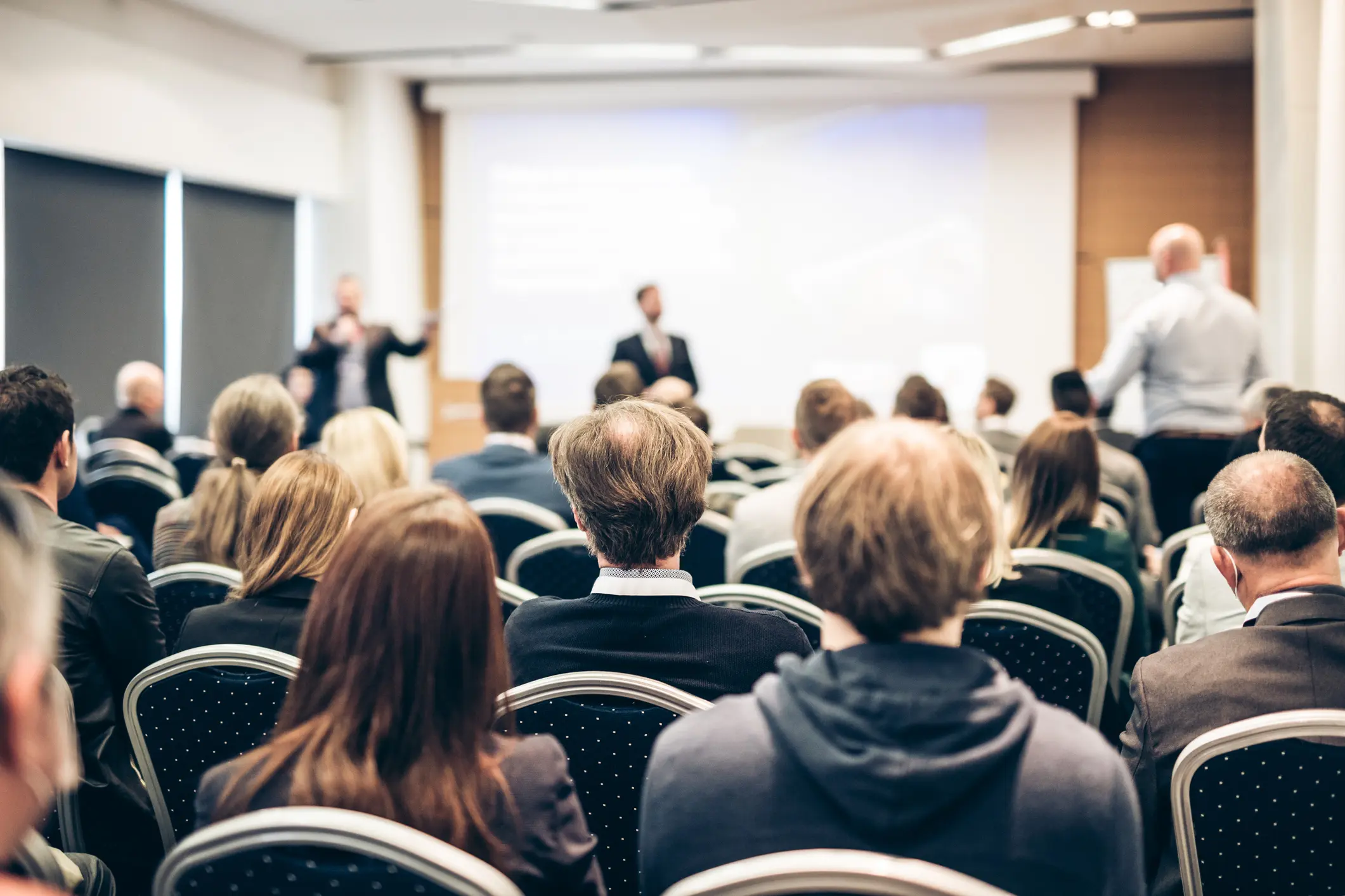 Audience attending a business presentation in conference.