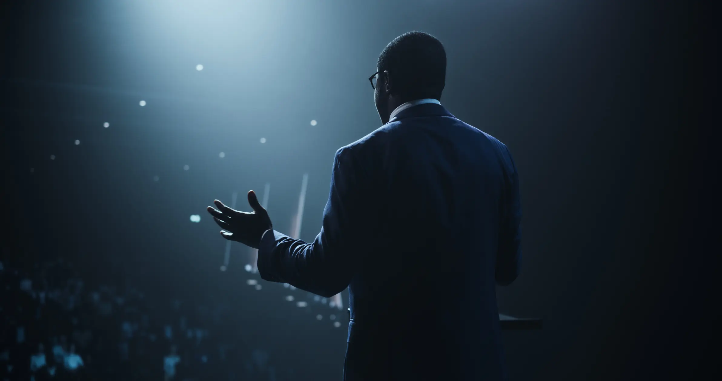 Speaker on stage in dim lighting.
