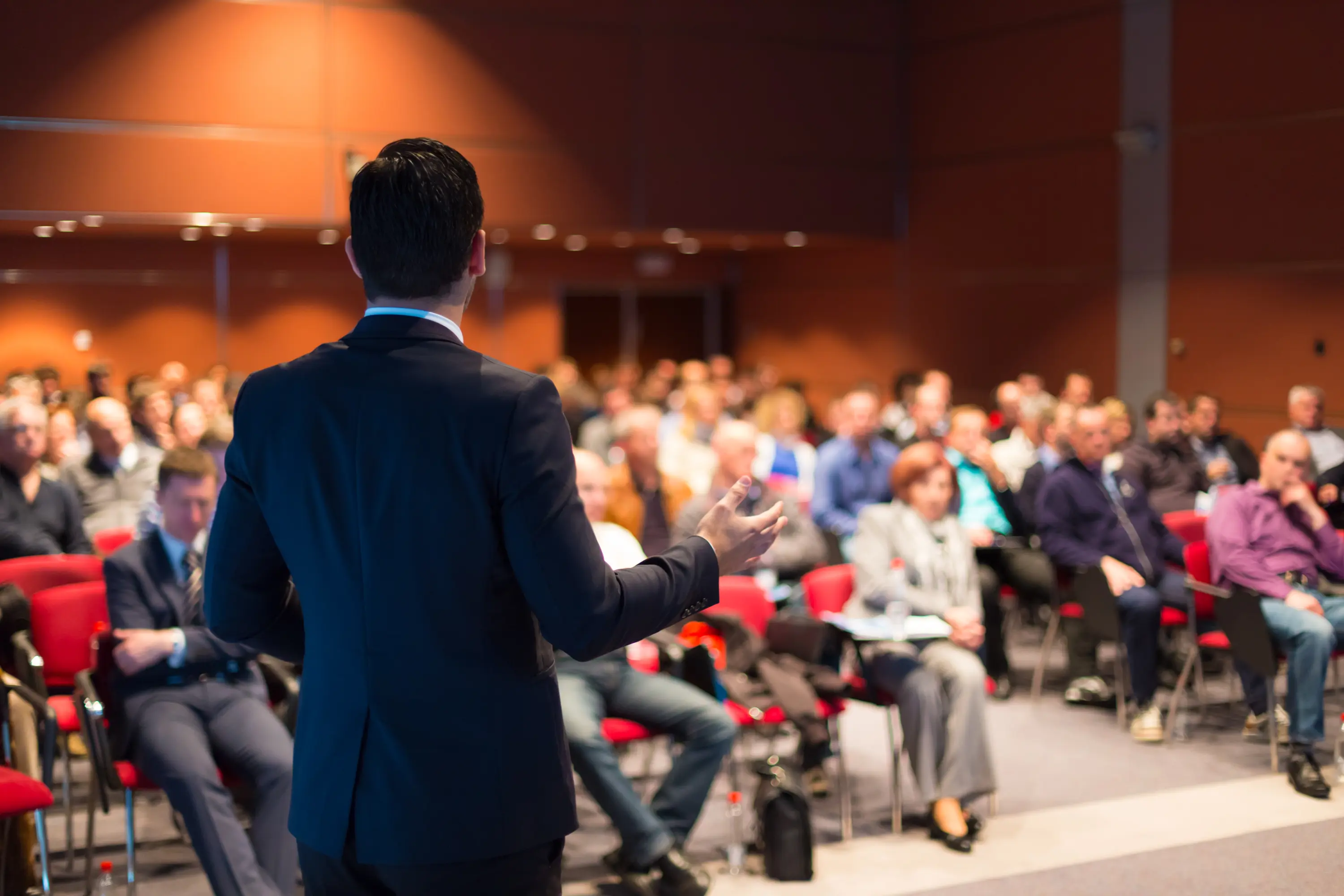 Speaker addressing audience at a conference.