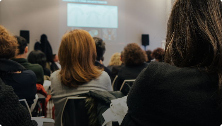 Audience attending a presentation in a room.