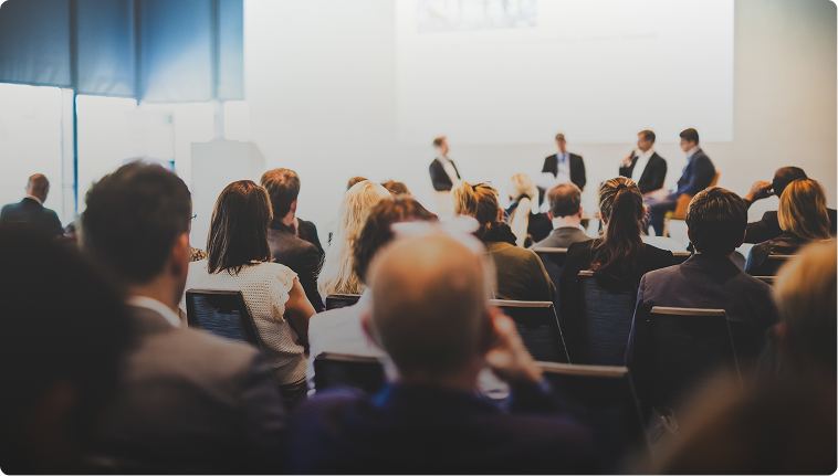 Audience attending a business conference panel discussion.